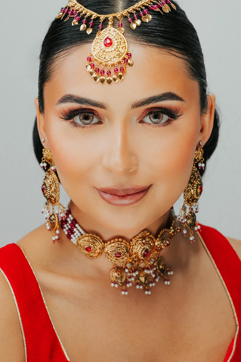 Model wearing a maang tikka, jhumka earrings and an antique gold choker, Sonei Jewellers Surrey
